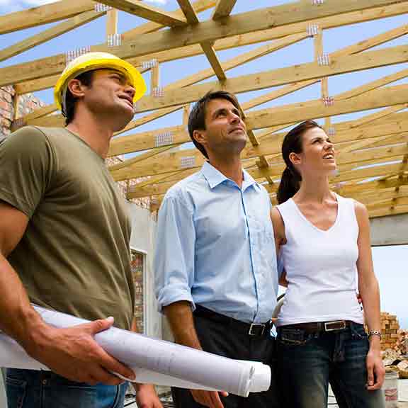 couple and builder in a half built house square