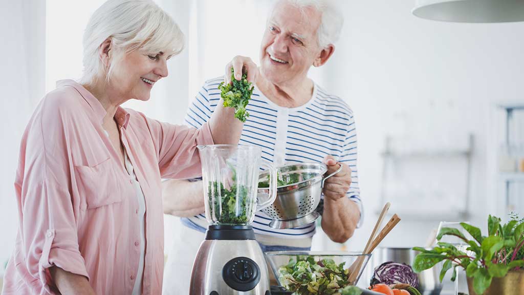 older couple using a blender at home