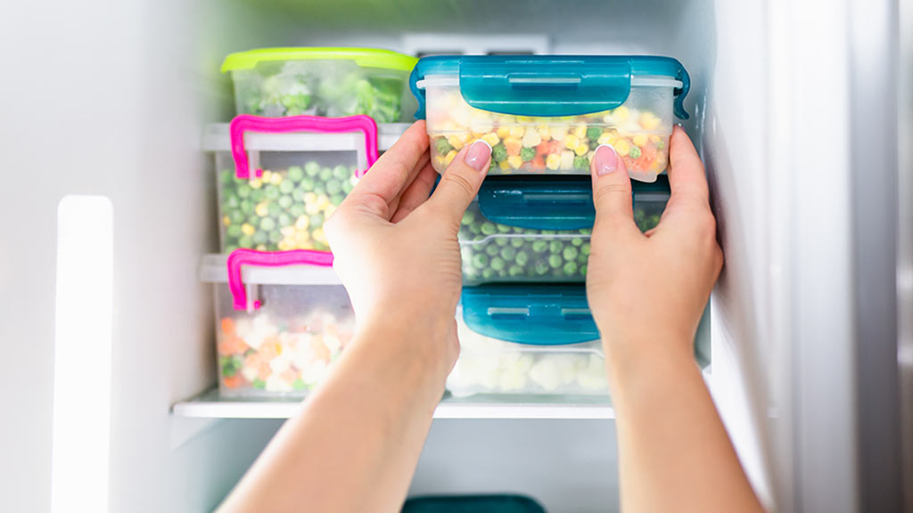 person putting food into a freezer