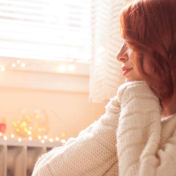 woman sitting in room with heater landing sq