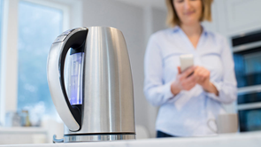 woman using kettle in kitchen